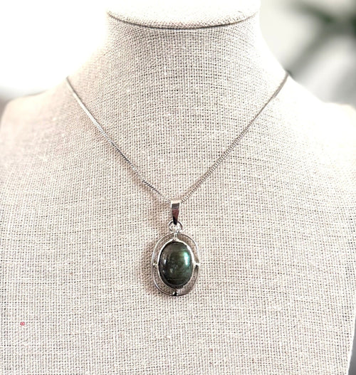 Necklace with a pendant on a mannequin bust against a blurred background